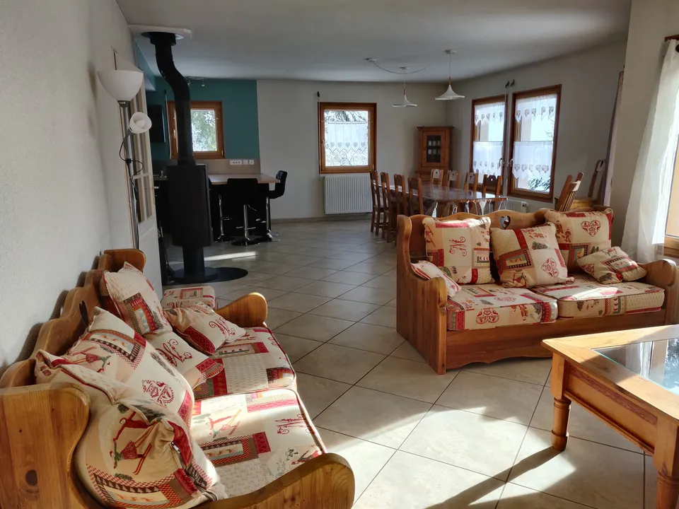 Salon avec poêle à bois et canapé convertible – Gîte Edelweiss (2)